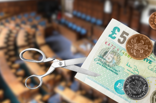 An image of scissors cutting cash with a background of the County Council chamber