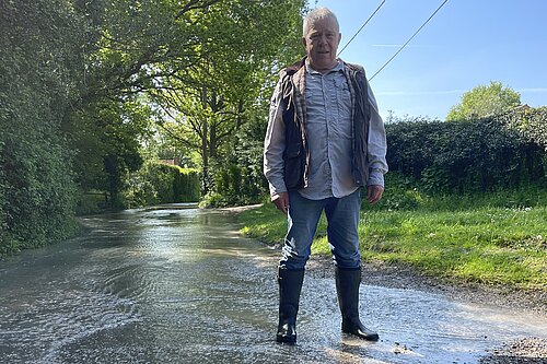 Cllr Kevin Chatburn standing on a flooded road