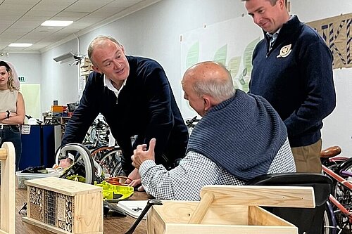 Ed Davey and Calum Miller being shown how to do electrical safety testing